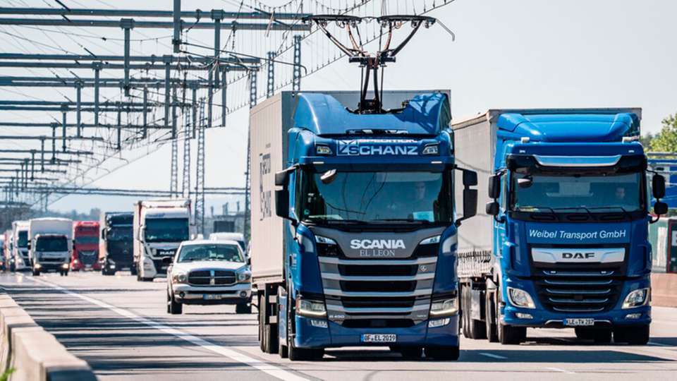 Eine Hybrid-Zugmaschine von Scania fährt mit ausgefahrenem Stromabnehmer auf der deutschen Teststrecke für E-Lastwagen mit Oberleitung auf der A5. 