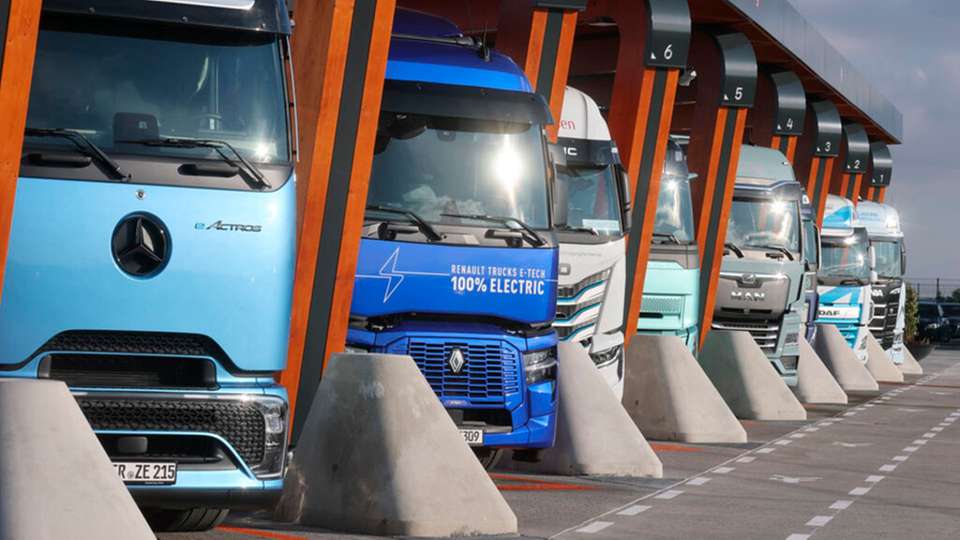 Lkw mit Elektroantrieb stehen in einer Ladebox bei der Einweihung eines Ladeparks für E-Lastwagen am Hermsdorfer Kreuz.