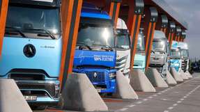 Lkw mit Elektroantrieb stehen in einer Ladebox bei der Einweihung eines Ladeparks für E-Lastwagen am Hermsdorfer Kreuz.