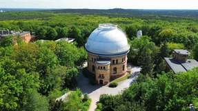 Der Schein trügt: Obwohl die Bäume auf dem Telegrafenberg in Potsdam in sattem Grün erstrahlen, ist der Bestand infolge von Hitze, Trockenheit und Wassermangel bereits zu 78 Prozent geschädigt. Ein Landschaftskonzept soll den Campus klimaresilient, biodivers und nachhaltig gestalten. 