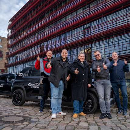 Daumen hoch für die Elektromobilität: Das Fuhrpark-Team von Coca-Cola feiert die vollständige Elektrifizierung der firmeneigenen Pkw- und Transporter-Flotte mit insgesamt 1.600 Fahrzeugen. 