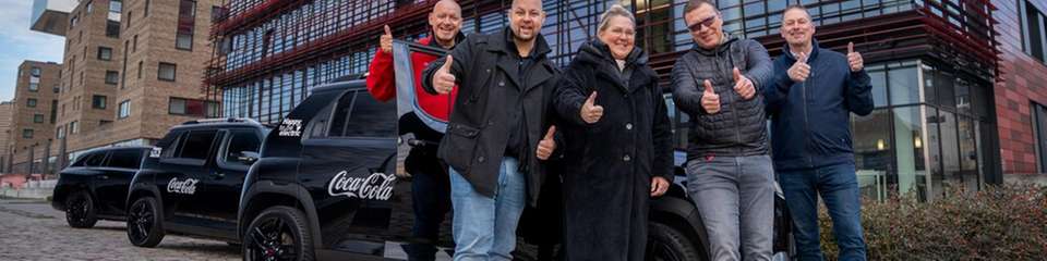 Daumen hoch für die Elektromobilität: Das Fuhrpark-Team von Coca-Cola feiert die vollständige Elektrifizierung der firmeneigenen Pkw- und Transporter-Flotte mit insgesamt 1.600 Fahrzeugen. 
