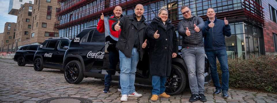 Daumen hoch für die Elektromobilität: Das Fuhrpark-Team von Coca-Cola feiert die vollständige Elektrifizierung der firmeneigenen Pkw- und Transporter-Flotte mit insgesamt 1.600 Fahrzeugen. 